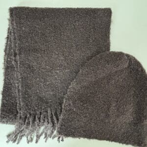 A gray scarf and hat on top of the floor.