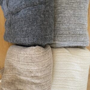 A pile of blankets and pillows in different colors.